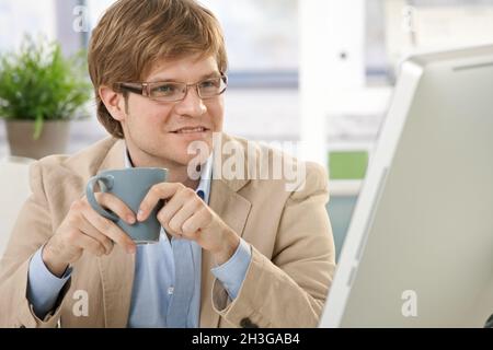 Un jeune homme d'affaires assis à boire du café Banque D'Images