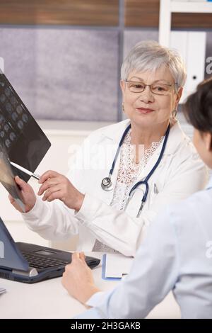 Médecin montrant les résultats d'acquisition au patient Banque D'Images