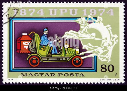 HONGRIE - VERS 1974 : un timbre imprimé en Hongrie montre Old Mail automobile, emblème de l'UPU, centenaire de l'Union postale universelle, vers 1974 Banque D'Images