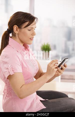 Employé de bureau utilisant un smartphone Banque D'Images