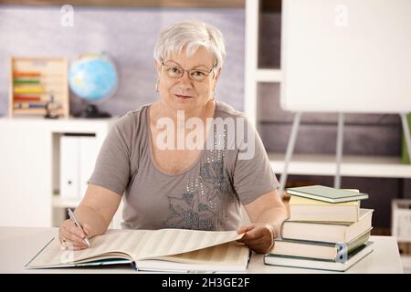 Professeur principal à l'école à la recherche dans un livre Banque D'Images