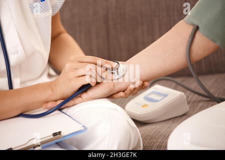 Gros plan de la main à l'aide d'un stéthoscope sur le poignet Banque D'Images