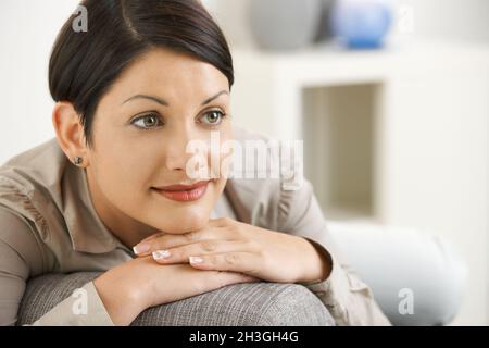 Belle femme se reposant sur un canapé à la maison Banque D'Images