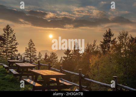 Tables avec bancs en bois dans les montagnes au coucher du soleil Banque D'Images