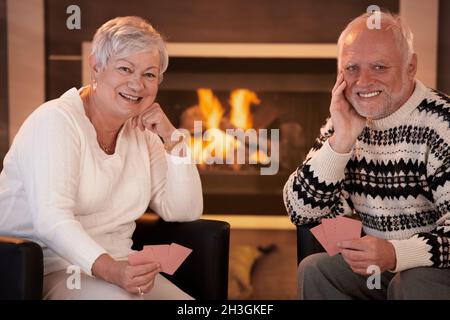 Happy senior couple jeux de cartes chez eux Banque D'Images