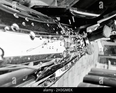 Gros plan en échelle de gris de gouttelettes d'eau sur la surface d'une voiture Banque D'Images