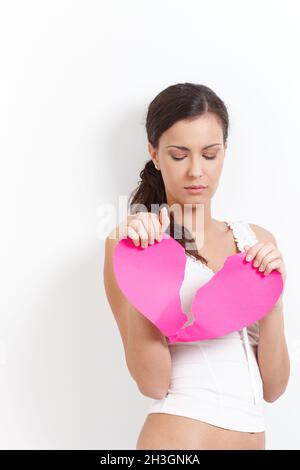 Femme cassée de coeur avec un coeur de papier Banque D'Images
