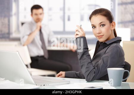 Portrait d'une femme attrayante assise au bureau Banque D'Images