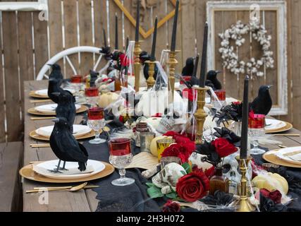 Table d'Halloween avec des cendre et des squelettes, des crânes, des corbeaux ou des corneilles.Table décorée pour Halloween.Sélectif foyer, personne, concept Hallowee Banque D'Images