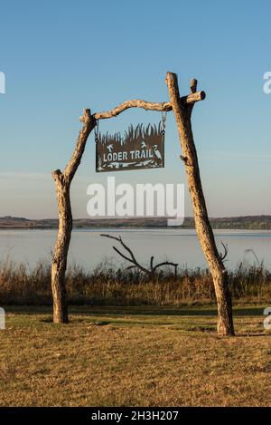 Une enseigne métallique artisanale accrochée à des poteaux et une barre transversale faite de troncs d'arbre marquent le chemin de la piste de Loder. Banque D'Images