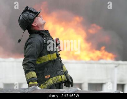 Jennings, États-Unis.28 octobre 2021.Un pompier de St. Louis se tient sur le toit d'une usine de boules de bowling abandonnée alors que des chariots à échelle entrent en place tandis que les flammes se développent lors d'un incendie à plusieurs alarmes à Jennings, Missouri, le jeudi 28 octobre 2021.Le feu à l'intérieur de l'ancienne usine qui a été abandonné depuis 2018, a créé une situation de Hazmat à partir de résines et d'autres matériaux qui ont été utilisés pour faire les boules de bowling.Photo par Bill Greenblatt/UPI crédit: UPI/Alay Live News Banque D'Images