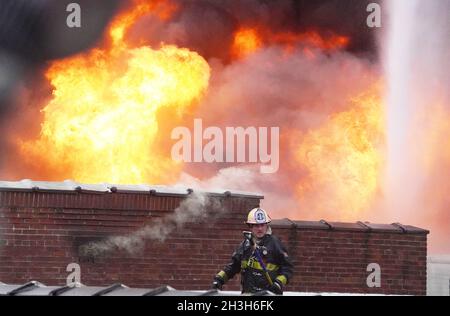 Jennings, États-Unis.28 octobre 2021.Le pompier de St. Louis Tom Moore attend de l'aide pour un incendie sur le toit d'une usine de boules de bowling abandonnée alors que les flammes se développent à un incendie à plusieurs alarmes à Jennings, Missouri, le jeudi 28 octobre 2021.Le feu à l'intérieur de l'ancienne usine qui a été abandonné depuis 2018, a créé une situation de Hazmat à partir de résines et d'autres matériaux qui ont été utilisés pour faire les boules de bowling.Photo par Bill Greenblatt/UPI crédit: UPI/Alay Live News Banque D'Images