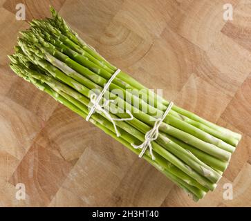 Asperges en paquet sur banc de bois Banque D'Images