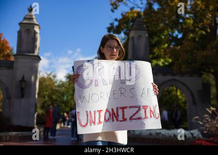 Bloomington, États-Unis.28 octobre 2021.Un membre de l'Indiana Grad Workers Coalition a une lecture de panneau, "Grad Workers are unionizing", lors de son dépôt à l'Indiana University Sample Gates à Bloomington.l'IGWC (Indiana Grad Workers Coalition) tente actuellement d'organiser un syndicat pour les employés diplômés de l'Indiana University.Crédit : SOPA Images Limited/Alamy Live News Banque D'Images