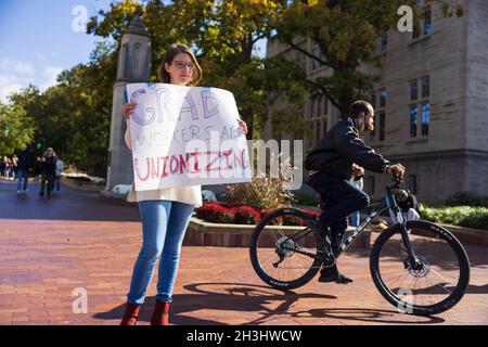 Bloomington, États-Unis.28 octobre 2021.Un membre de l'Indiana Grad Workers Coalition a une lecture de panneau, "Grad Workers are unionizing", lors de son dépôt à l'Indiana University Sample Gates à Bloomington.l'IGWC (Indiana Grad Workers Coalition) tente actuellement d'organiser un syndicat pour les employés diplômés de l'Indiana University.Crédit : SOPA Images Limited/Alamy Live News Banque D'Images