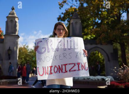 Bloomington, États-Unis.28 octobre 2021.Un membre de l'Indiana Grad Workers Coalition a une lecture de panneau, "Grad Workers are unionizing", lors de son dépôt à l'Indiana University Sample Gates à Bloomington.l'IGWC (Indiana Grad Workers Coalition) tente actuellement d'organiser un syndicat pour les employés diplômés de l'Indiana University.Crédit : SOPA Images Limited/Alamy Live News Banque D'Images