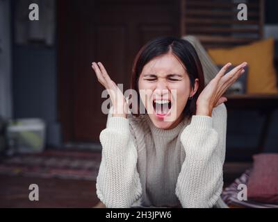 Jeune femme asiatique déprimée assise sur le porche de l'arrière-cour.Elle se sent triste et inquiète de souffrir de dépression en santé mentale.Santé mentale, anxiété dépressive pensant chinoise dame. Banque D'Images