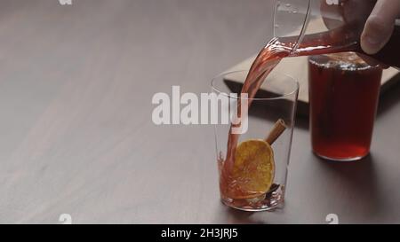 homme servant main de vin chaud dans des verres à verre mince sur table en noyer, grande photo Banque D'Images