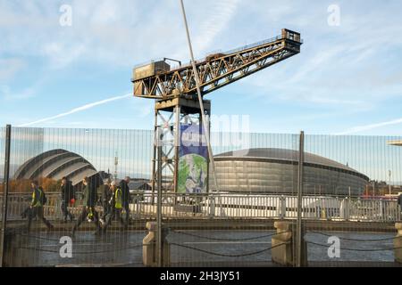 COP26: Les travailleurs derrière la barrière de sécurité en acier avec les sites de la zone bleue de la SEC en arrière-plan tandis que Glasgow se prépare à accueillir la conférence. Banque D'Images