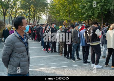 Les résidents s'alignent pour recevoir des tirs de rappel contre le COVID-19 sur un site de vaccination à Beijing, en Chine.29 octobre 2021 Banque D'Images