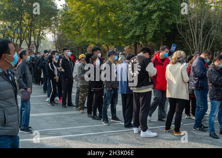 Les résidents s'alignent pour recevoir des tirs de rappel contre le COVID-19 sur un site de vaccination à Beijing, en Chine.29 octobre 2021 Banque D'Images