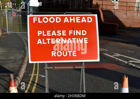 Gros plan sur l'enseigne métallique rouge et blanche. Conseils sur Flood Ahead, veuillez trouver un autre itinéraire en raison des eaux d'une rivière gonflée en hiver Banque D'Images