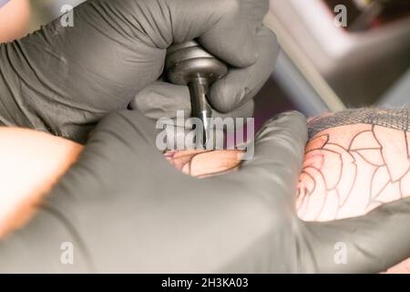 Gros plan d'un tatouage artiste plaçant un tatouage Banque D'Images