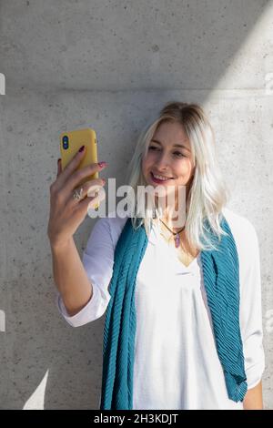 une jeune femme blonde professionnelle utilisant un smartphone. selfie Banque D'Images