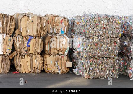 Piles de boîtes en carton et de bouteilles en plastique stockées pour recyclage Banque D'Images