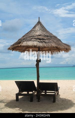 Plage tropicale avec transats et parasol sur l'eau de mer de la lagune Banque D'Images