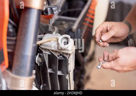 Mécanicien de moto, remplacement du radiateur de refroidissement.Remplacement ou entretien du radiateur. Banque D'Images