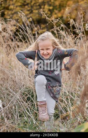 Fille s'amusant dans le champ de roseaux secs.Promenade en famille en automne dans la forêt Banque D'Images