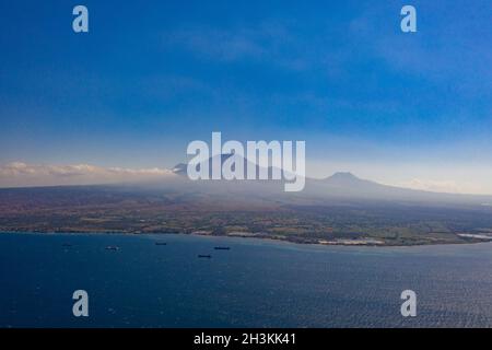 Vue aérienne sur un paysage marin magnifique avec des bateaux sur l'île avec fond de volcan en Indonésie Banque D'Images