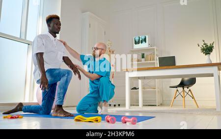 Santé du dos.A Мan effectue des exercices de dos, qui rétablissez les fonctions physiques, dans la clinique de réadaptation moderne.Concept de soins de santé Banque D'Images