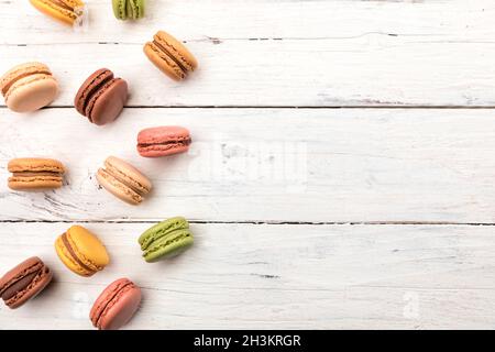 Arrière-plan rustique en bois avec une variété de macarons colorés, petits gâteaux français vue en grand angle avec espace de copie Banque D'Images