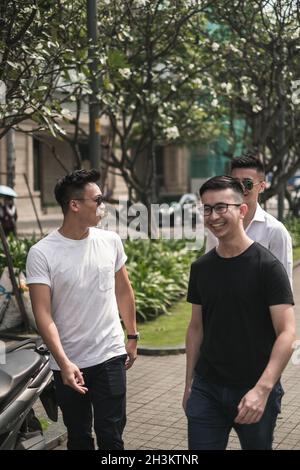 Portrait de trois jeunes hommes asiatiques vêtés de vêtements décontractés marchant dans la rue et souriant.Asie, peuple chinois, concept de la vie réelle, groupe d'amis Banque D'Images