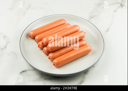 saucisses de poulet frais sur une grande plaque en céramique et un comptoir en marbre Banque D'Images