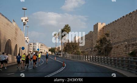 Les coureurs courent près des murs de la vieille ville pendant le 10ème Marathon international de Jérusalem le 29 octobre 2021 à Jérusalem, Israël.Quelque 20,000 personnes se sont inscrites pour participer au Marathon de Jérusalem qui est le plus grand événement de course en Israël.