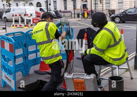 « G.Network' ingénieurs connectant des câbles réseau Internet haut débit à fibre optique à l'intérieur d'un boîtier « nœud », dans la région de Fitzrovia, Londres, Angleterre, Royaume-Uni Banque D'Images