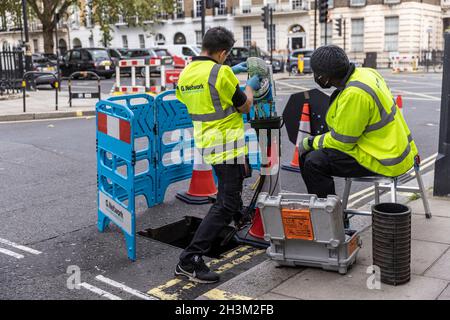 « G.Network' ingénieurs connectant des câbles réseau Internet haut débit à fibre optique à l'intérieur d'un boîtier « nœud », dans la région de Fitzrovia, Londres, Angleterre, Royaume-Uni Banque D'Images