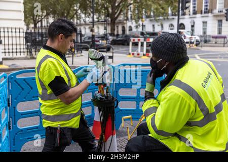 « G.Network' ingénieurs connectant des câbles réseau Internet haut débit à fibre optique à l'intérieur d'un boîtier « nœud », dans la région de Fitzrovia, Londres, Angleterre, Royaume-Uni Banque D'Images