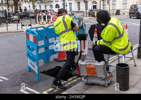 « G.Network' ingénieurs connectant des câbles réseau Internet haut débit à fibre optique à l'intérieur d'un boîtier « nœud », dans la région de Fitzrovia, Londres, Angleterre, Royaume-Uni Banque D'Images