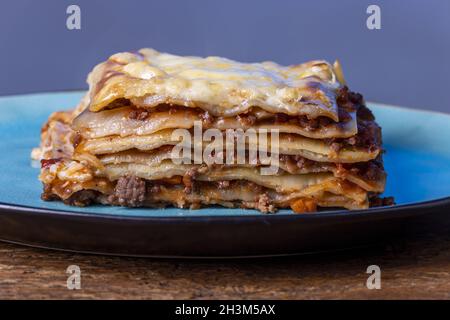 Portion de lasagne fraîche sur une assiette bleue Banque D'Images