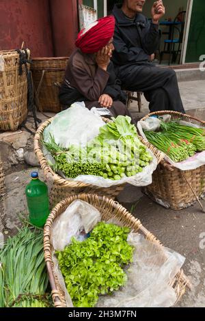 Exposition de salade et de légumes en vente sur le marché de rue offert à la vente / vendu par un homme / des hommes ethniques, probablement du Tibet, résident ou local à l'ancienne ville chinoise fortifiée (ancienne ville fortifiée) de Songpan dans le nord du Sichuan, en Chine.(125) Banque D'Images