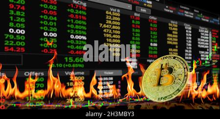 Pièces en bitcoin d'or à la flamme du feu et à l'arrière-plan de la table de lecture Banque D'Images