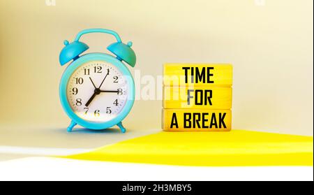 Blocs en bois avec le texte heure pour une pause, sur un fond clair avec une horloge. Banque D'Images