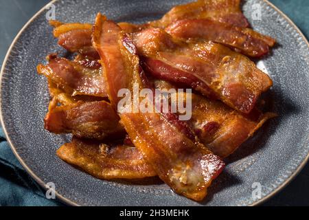 Bacon graisseux pour le petit déjeuner sur une assiette Banque D'Images