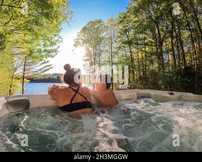 Un garçon et sa mère se détendent dans un bain à remous avec vue sur le lac. Banque D'Images