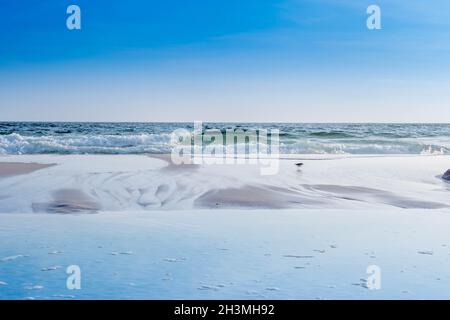 Une belle mer vagues whitecap rouler sur le plage de sable fin de la Côte d'Emeraude Banque D'Images