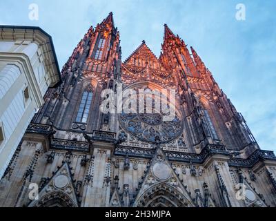 Façade (ouest) de la cathédrale de Prague au coucher du soleil : la lueur d'un soleil rose illumine les deux flèches de la grande cathédrale gothique de Prague de Saint-Vitus. Banque D'Images